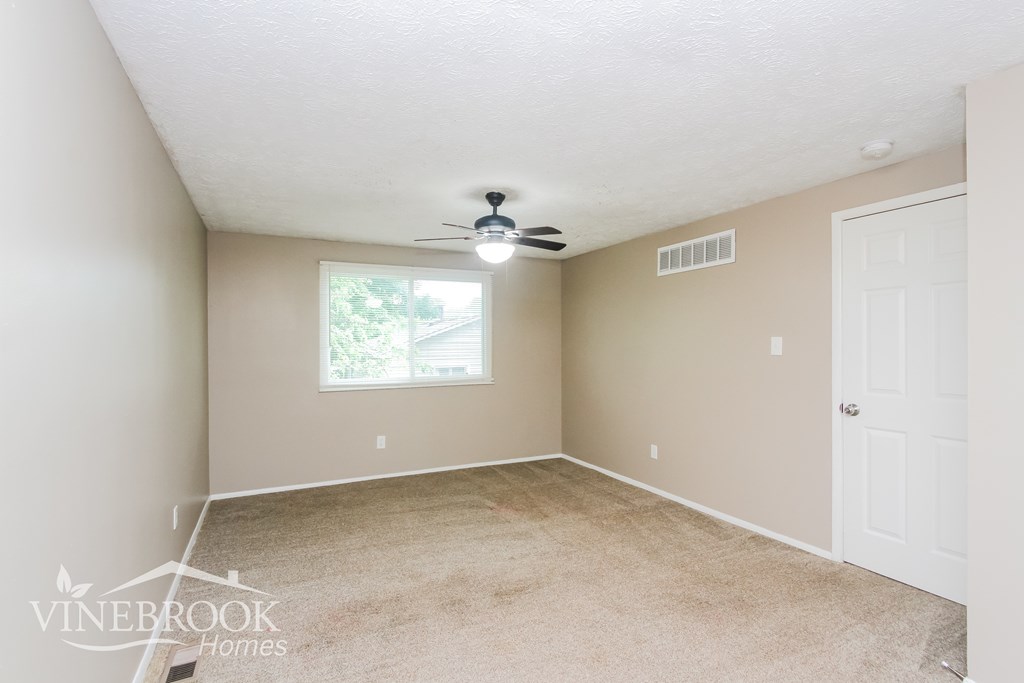 A room with a window and a ceiling fan.