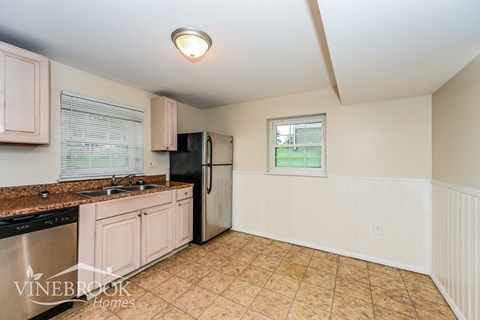 A kitchen with Vinebrook Homes written on the wall.