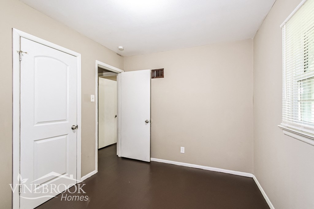 a bedroom with a white door and a door to a closet