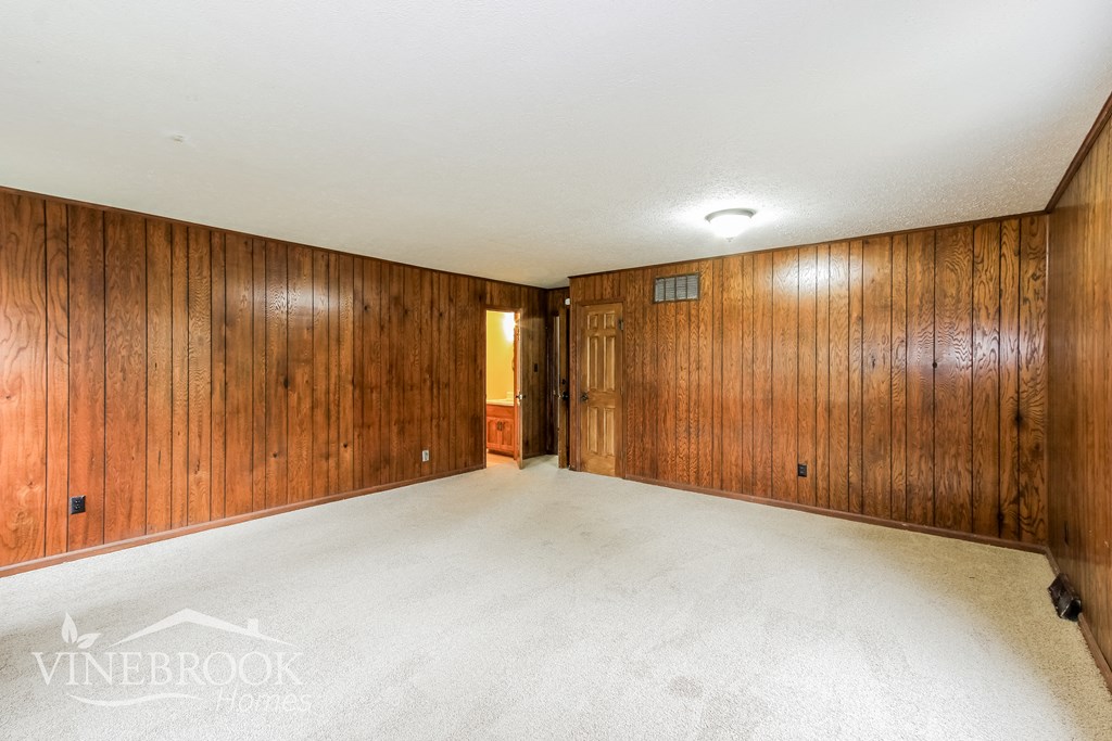 an empty room with wood paneled walls and a white floor