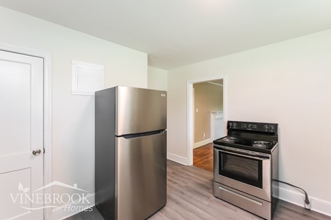 A modern kitchen with a stainless steel refrigerator and oven.