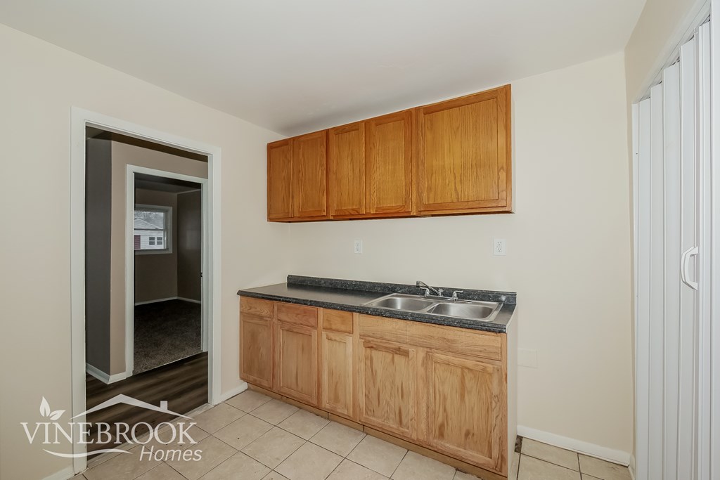 A kitchen with wooden cabinets and a sink.