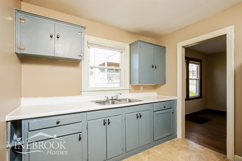 A kitchen with blue cabinets and a white countertop.