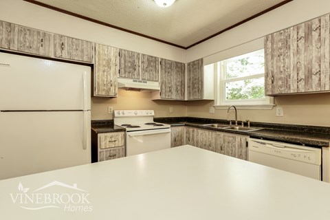 A kitchen with wooden cabinets and a white refrigerator.