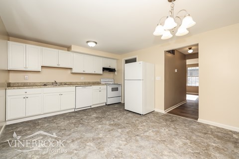 A kitchen with white cabinets and appliances is on the market.