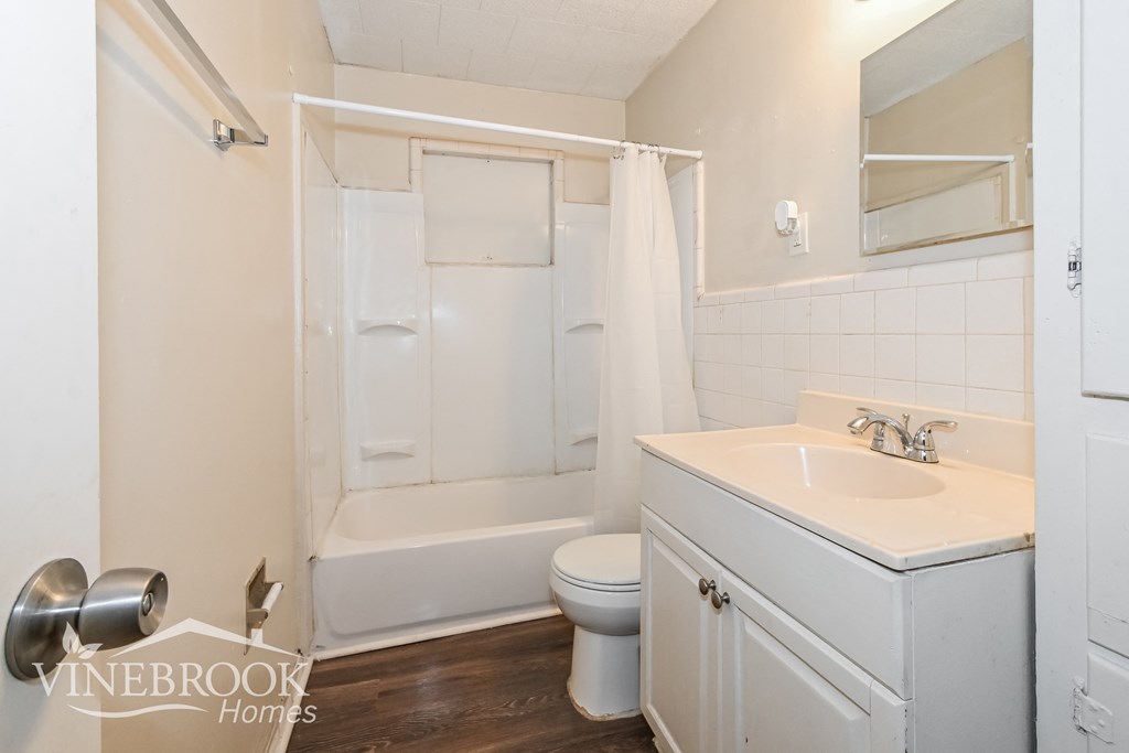a white bathroom with a sink toilet and shower
