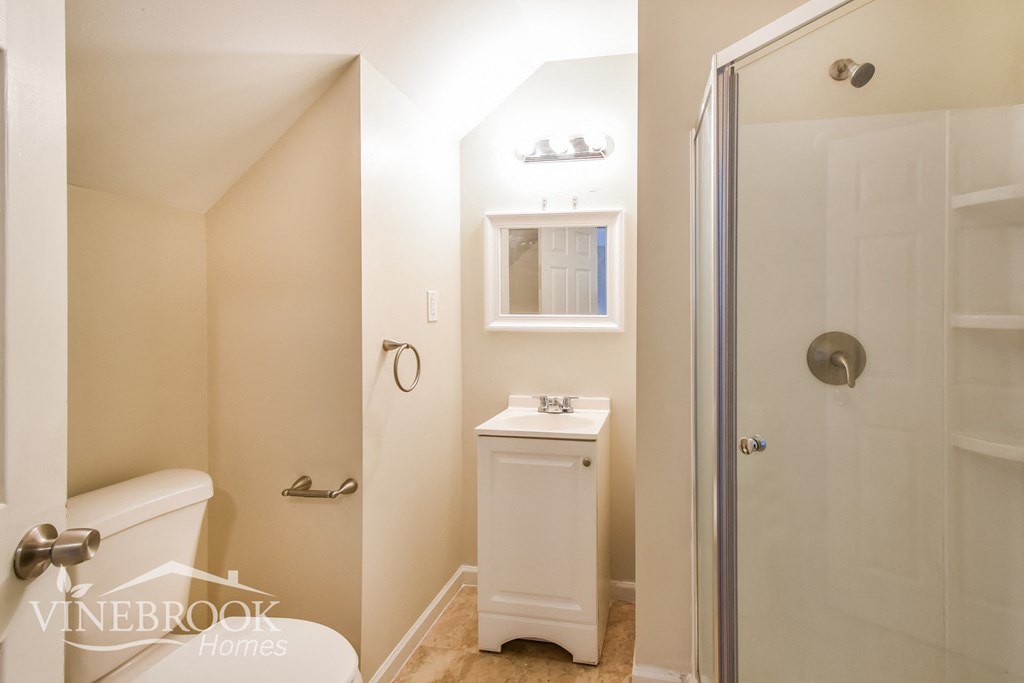 a bathroom with a shower and a sink and a toilet