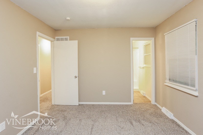 a bedroom with a closet and a window and a door