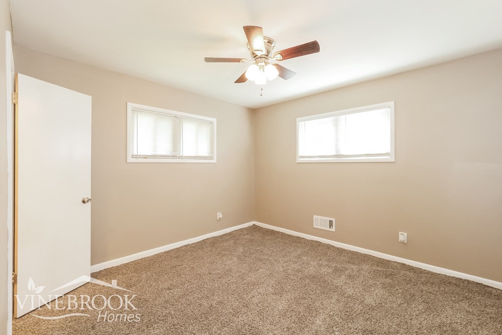 a bedroom with carpet and a ceiling fan