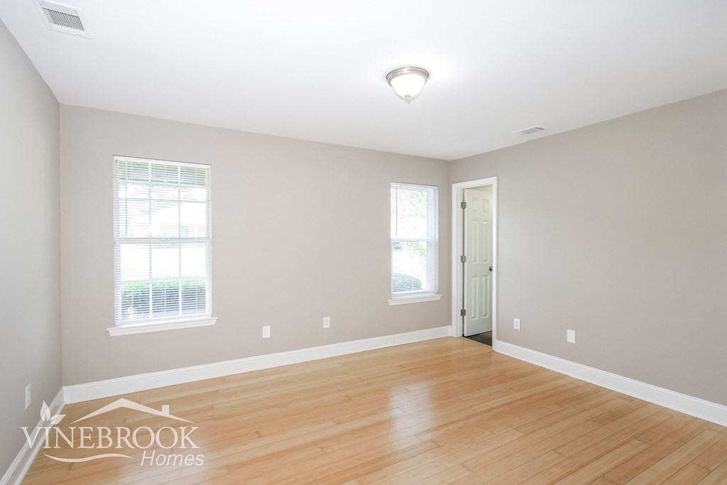 a living room with a hard wood floor and a white door