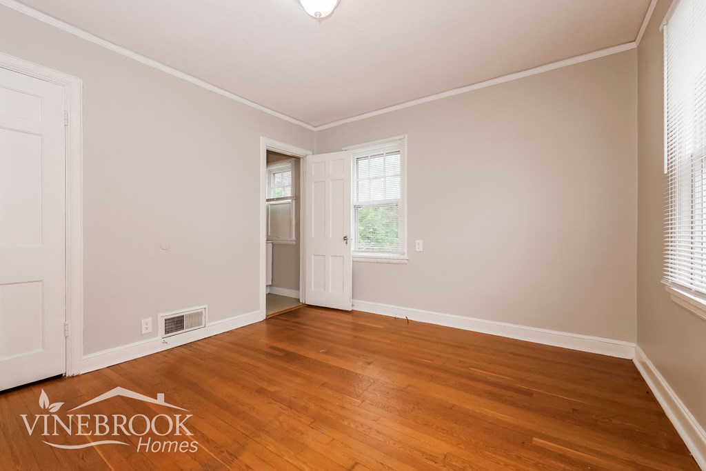 the living room of a home with wood floors and white walls