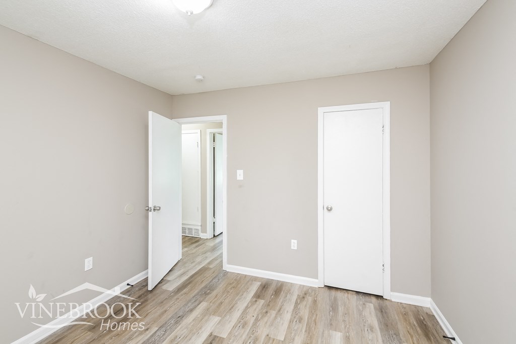 a renovated living room with wood floors and white walls