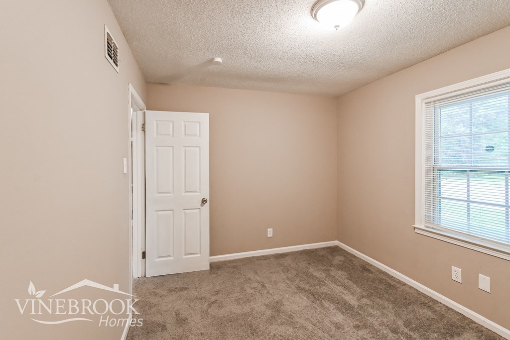 a bedroom with a carpeted floor and a white door