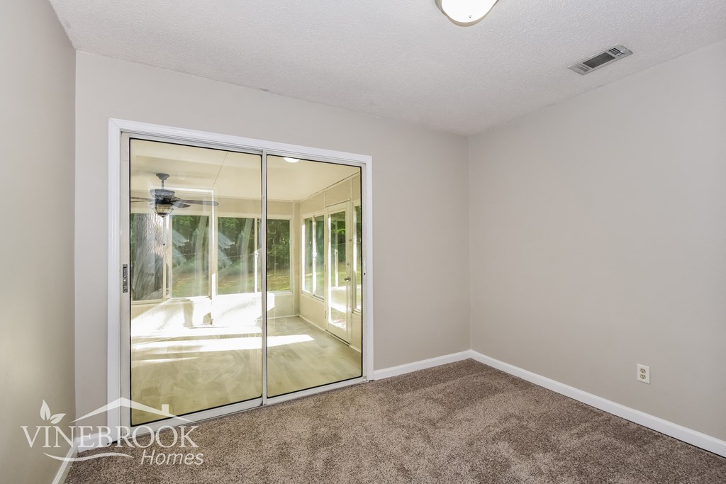 a bedroom with a large mirror and carpeted flooring