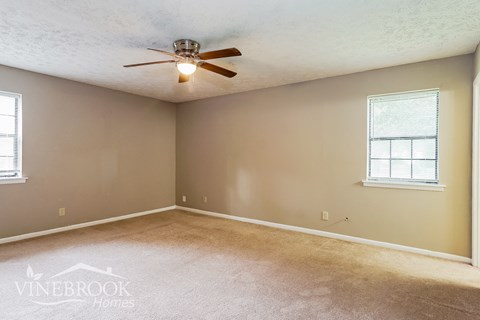 the living room of an empty house with a ceiling fan