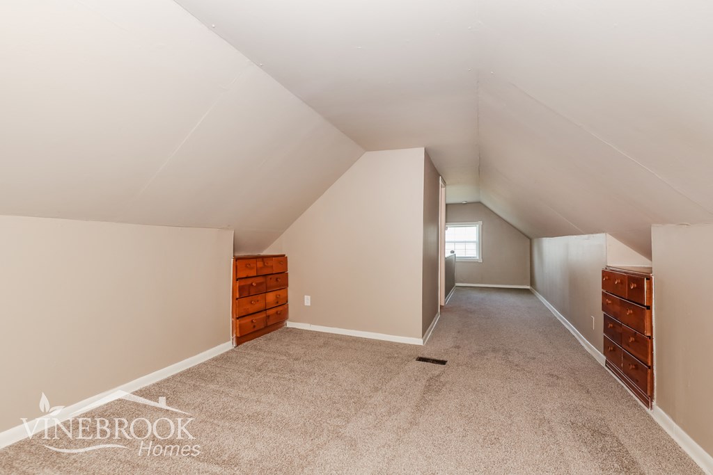 two closets in a loft room with carpeting and white walls