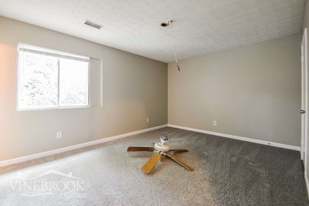 an empty living room with a toy plane on the floor