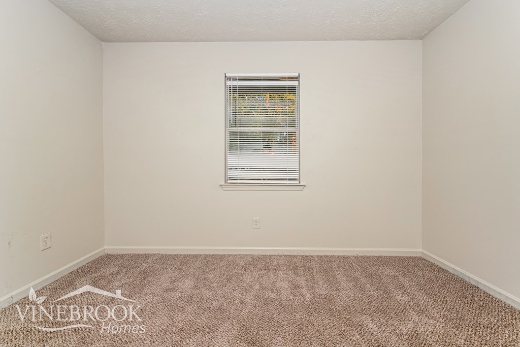the upstairs bedroom has carpet and a window