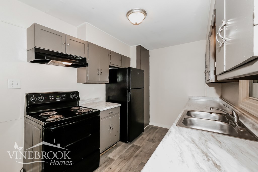 A kitchen with a black stove and black refrigerator.