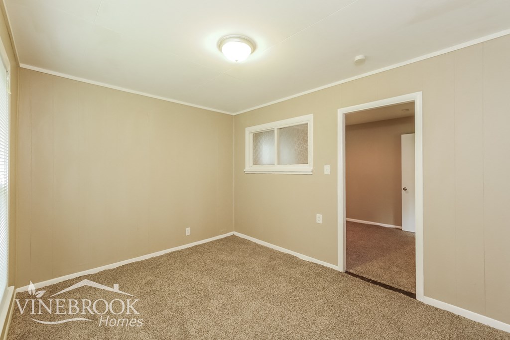 a bedroom with a carpeted floor and a door to a closet