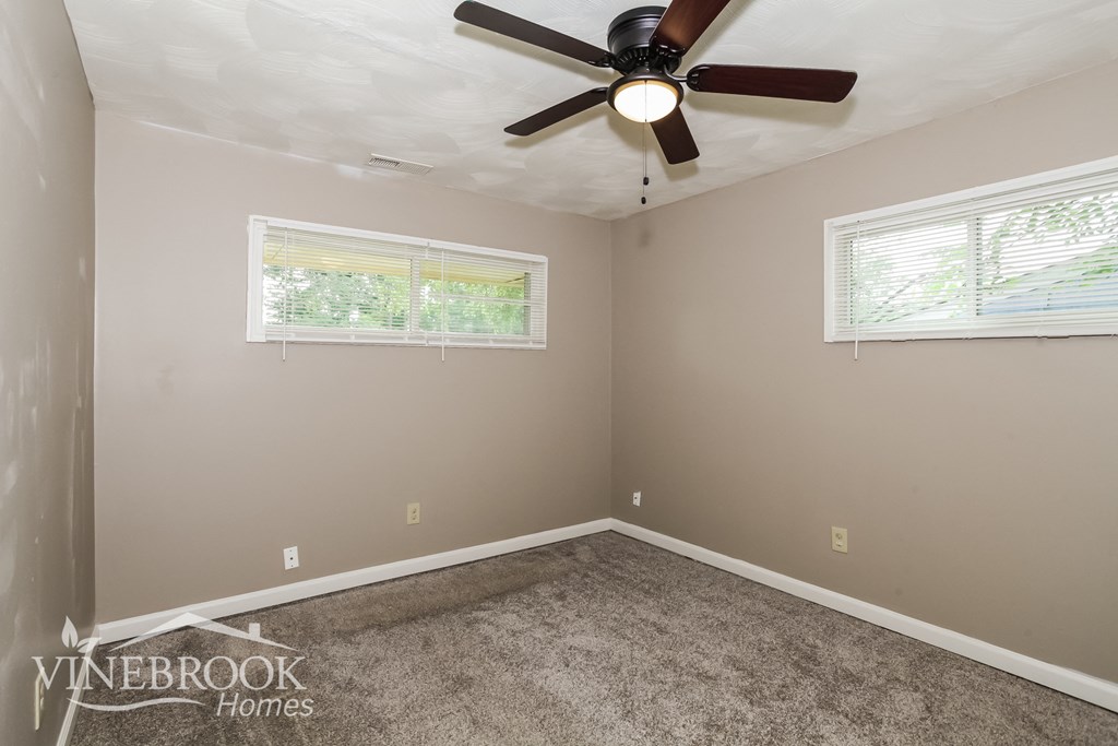 the living room of a home with a ceiling fan and carpet
