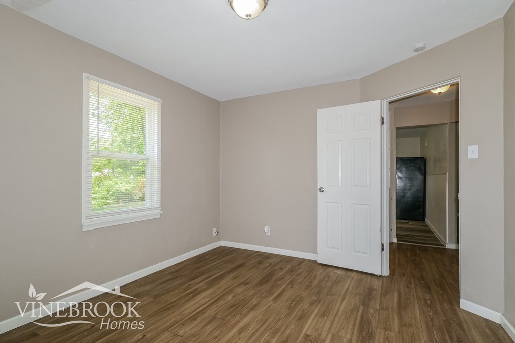 the living room of a home with a wooden floor and a white door
