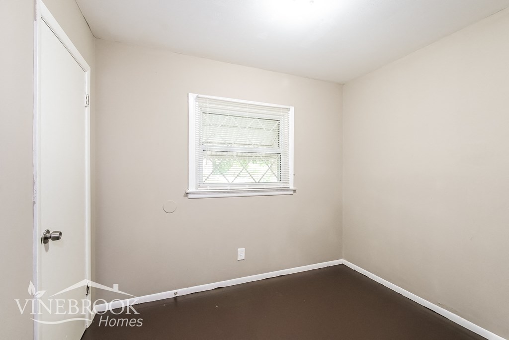 a small room with a window and a white door