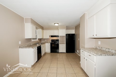 A kitchen with white cabinets and appliances is shown.