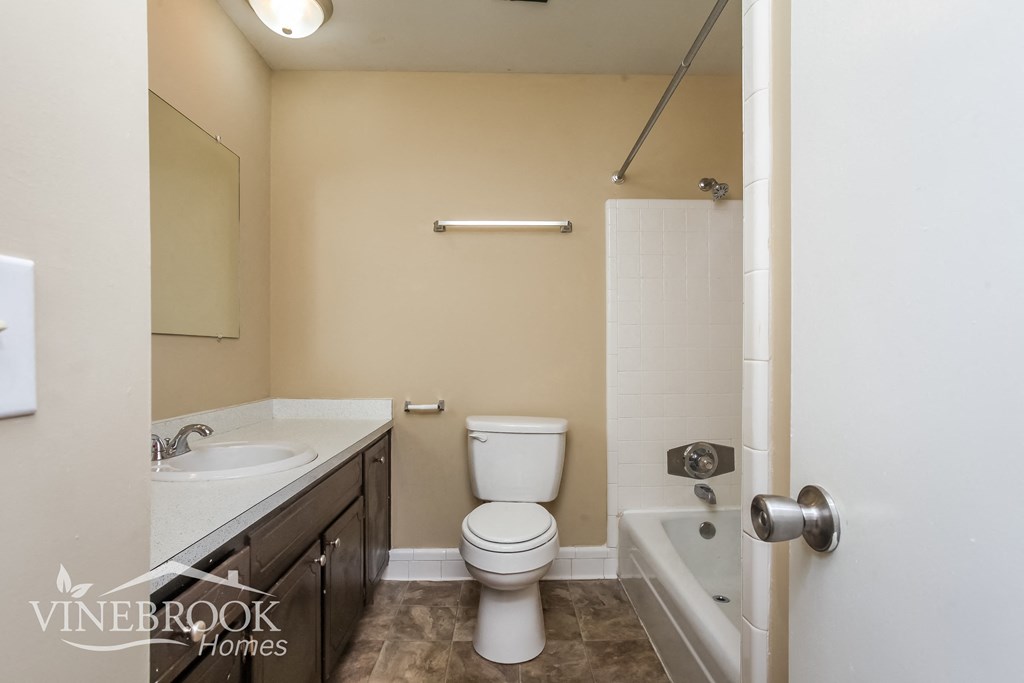 a bathroom with a toilet sink and shower and a tub