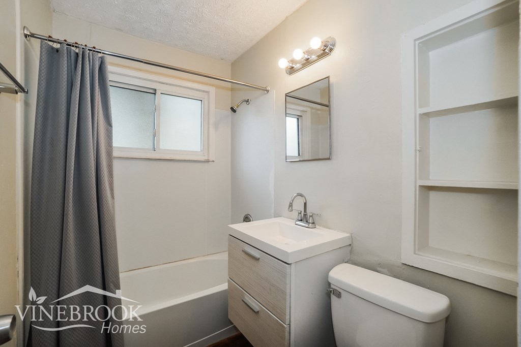 a small bathroom with a white toilet and a sink and a shower