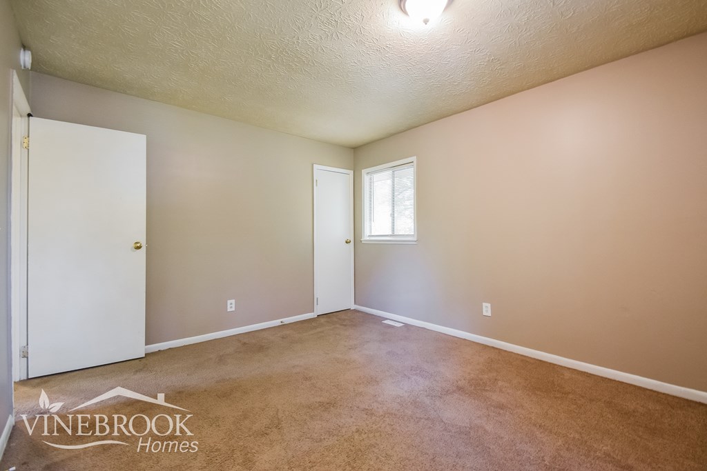 the living room of a home with a carpeted floor and a white door