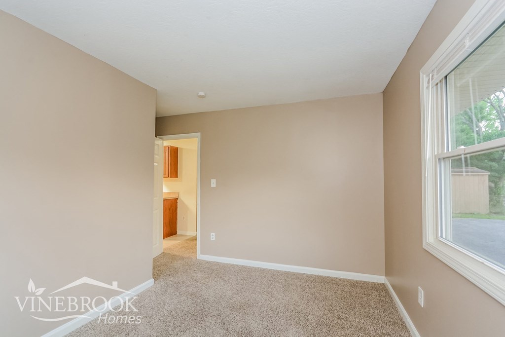 a bedroom with a carpeted floor and a large window