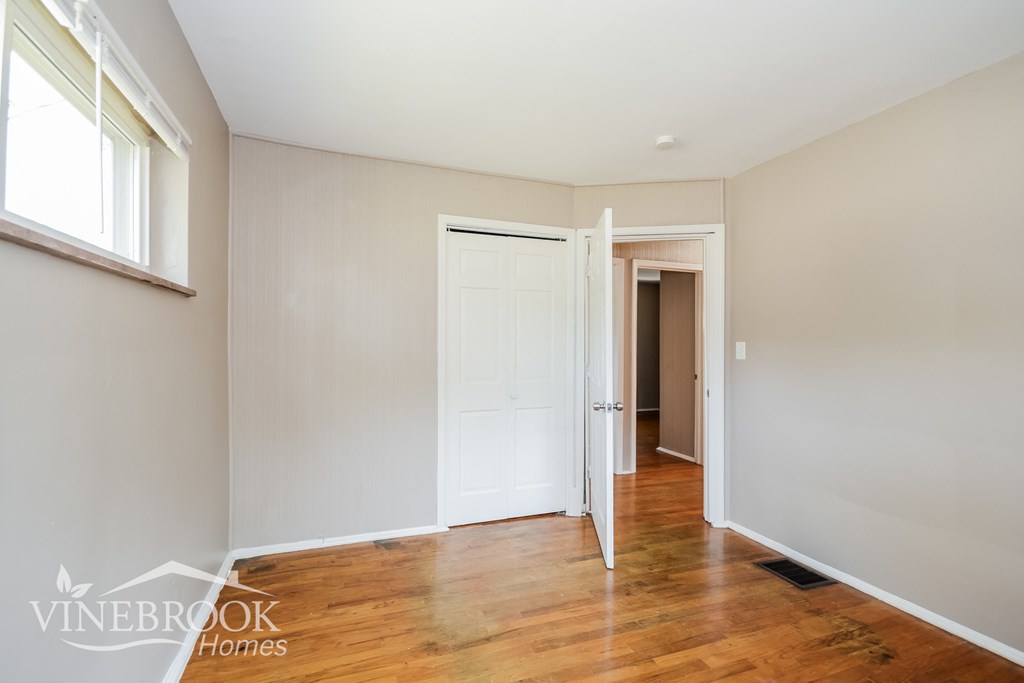 a renovated living room with wood floors and a white door