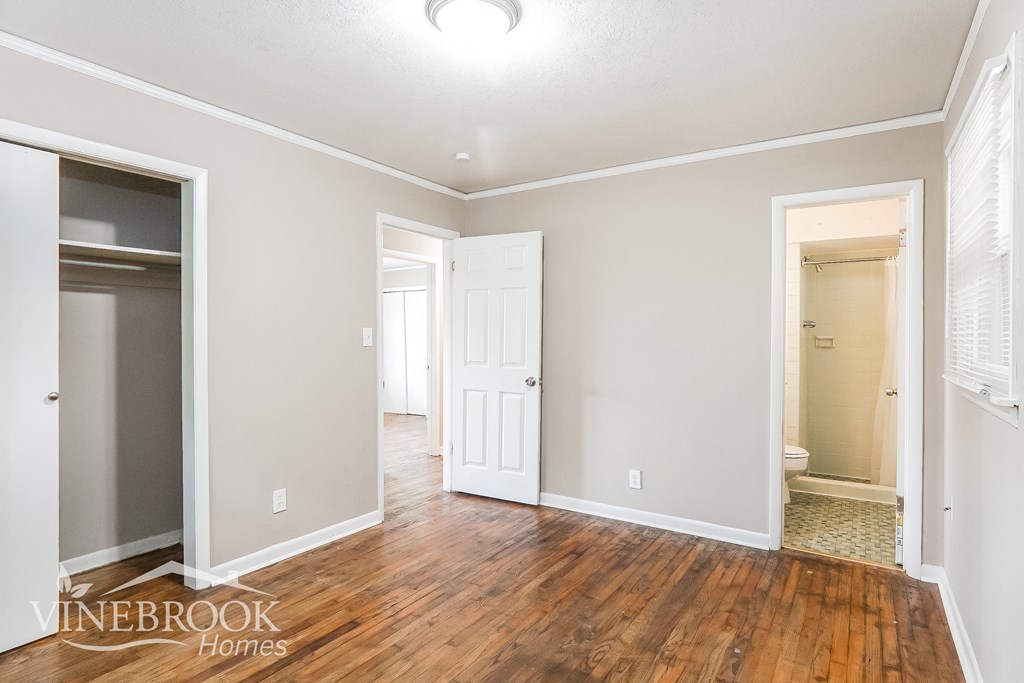 a living room with a hard wood floor and a door to a closet