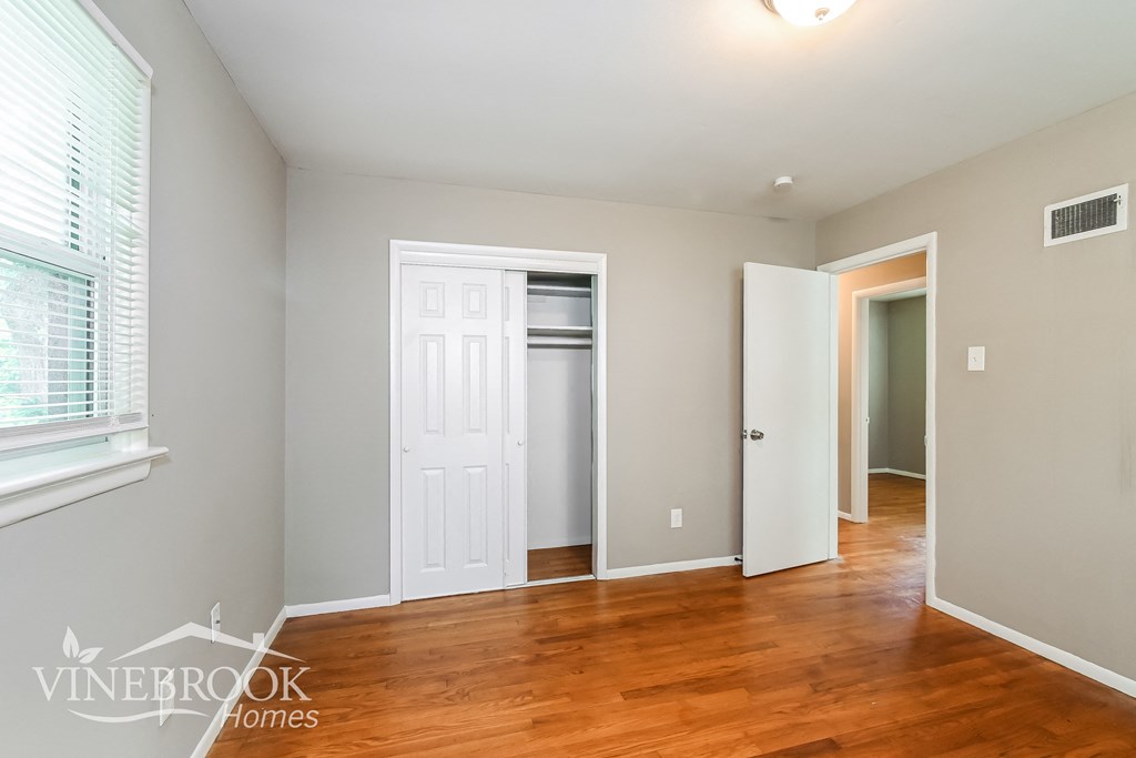 a renovated living room with wood flooring and a closet