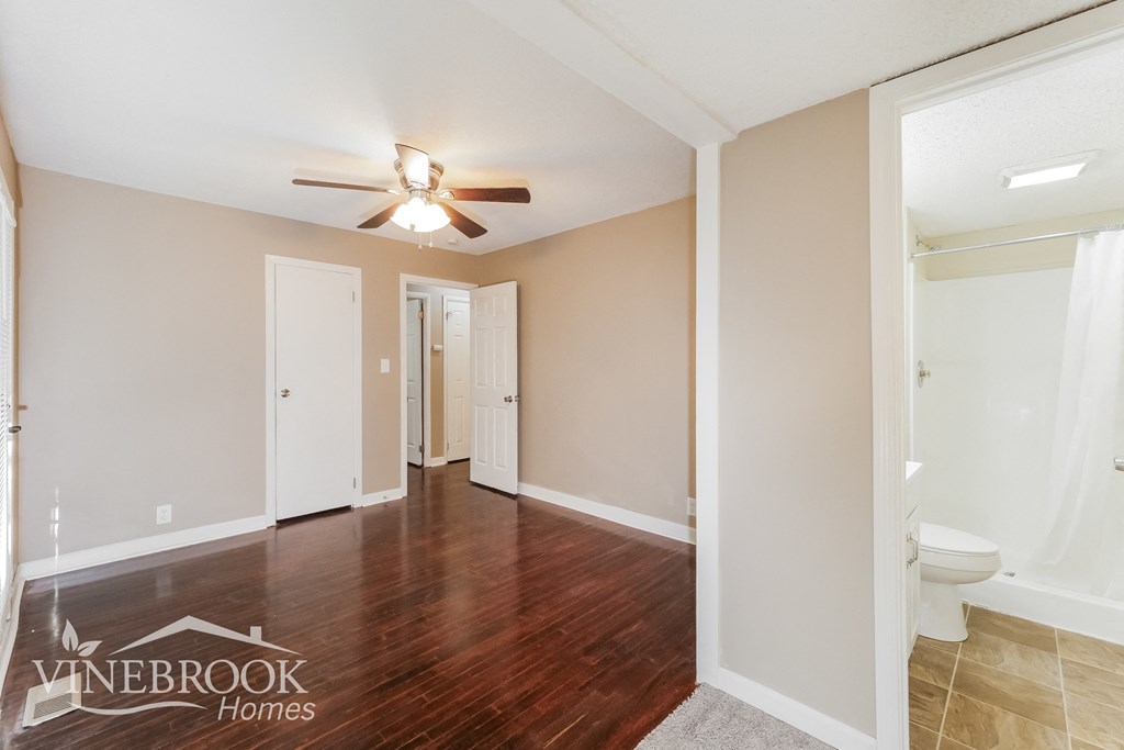 a living room with wood flooring and a ceiling fan