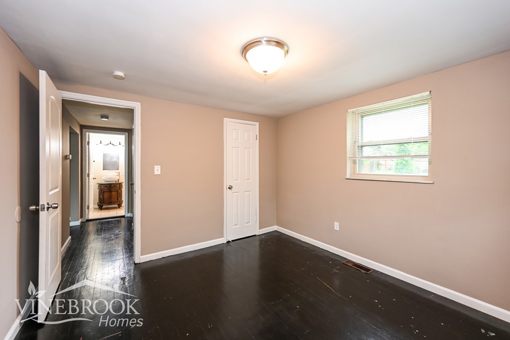 A room with a white ceiling, a window, and a door.