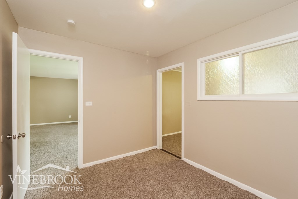a bedroom with a carpeted floor and a door to a closet