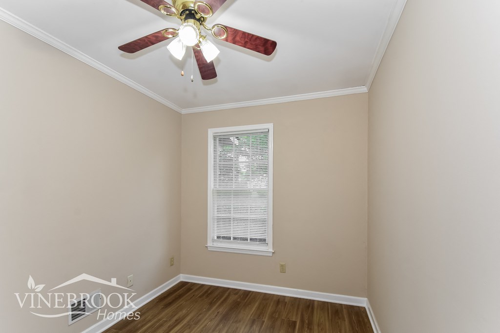 a bedroom with a ceiling fan and a window