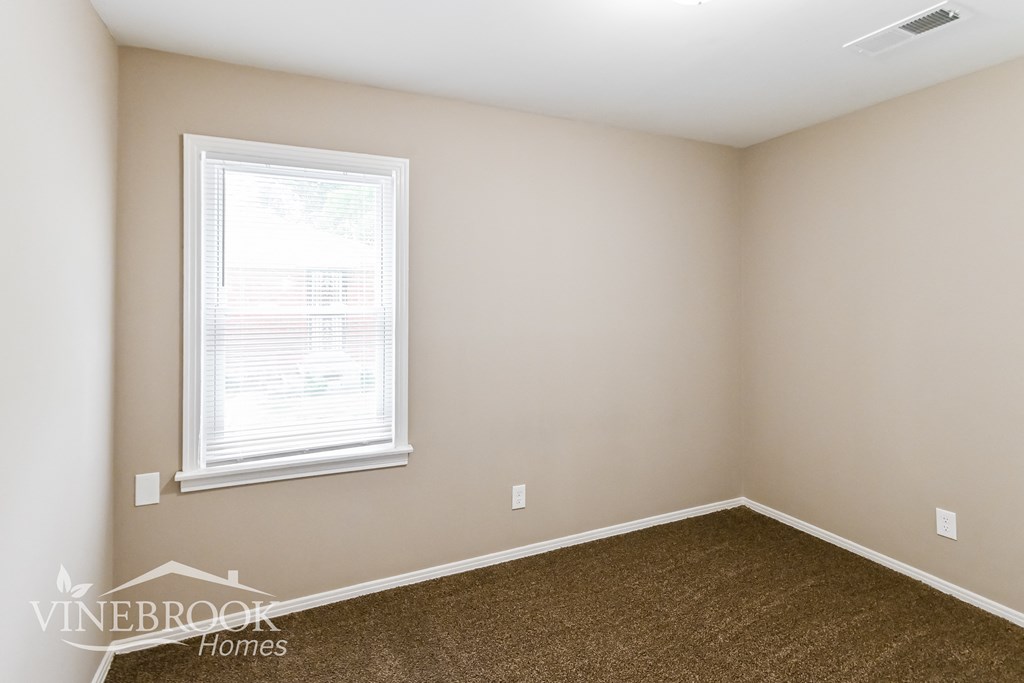 a bedroom with a carpeted floor and a window