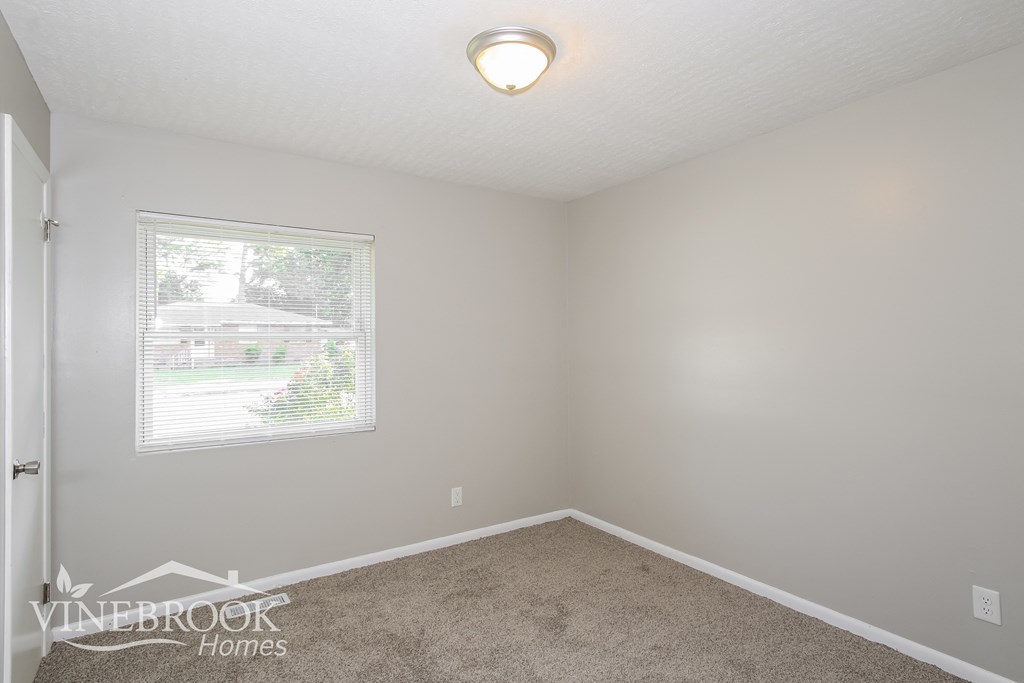 a bedroom with a carpeted floor and a window