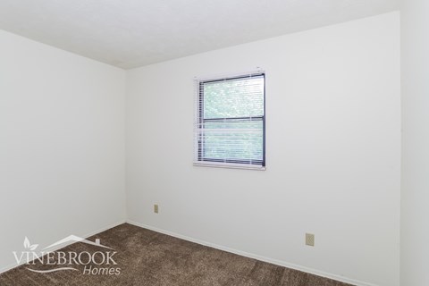 the living room of a home with a carpet and a window