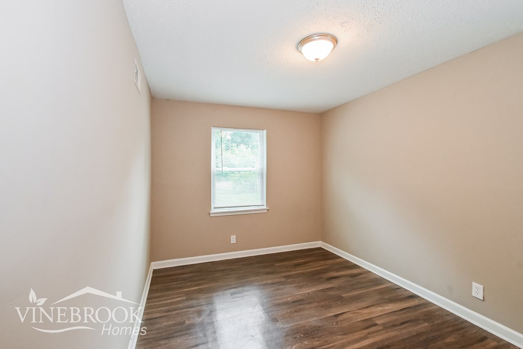 a empty room with a wood floor and a window