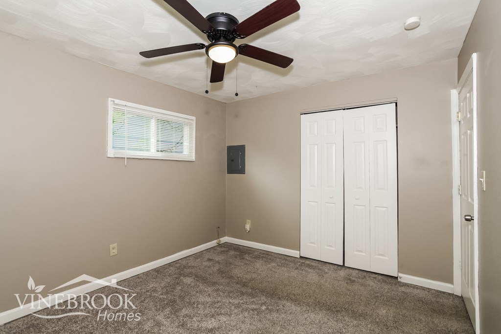 a bedroom with a ceiling fan and a closet