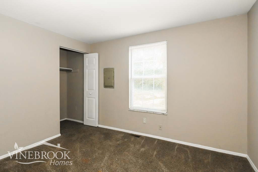 a room with a door to a closet and a carpeted floor