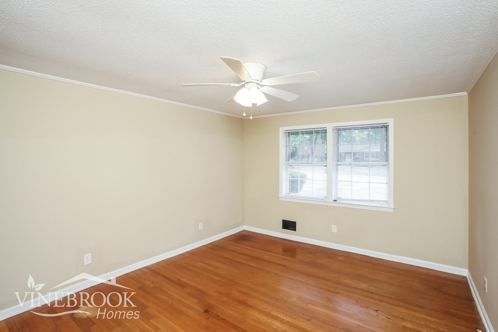 a bedroom with hardwood flooring and a ceiling fan