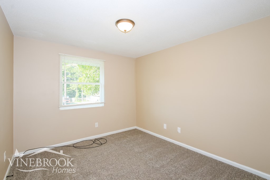 a empty room with carpet and a window