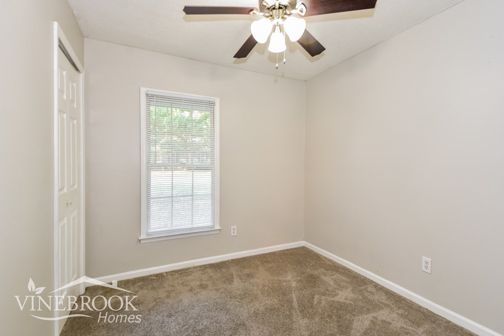 the living room of a home with a ceiling fan and carpet