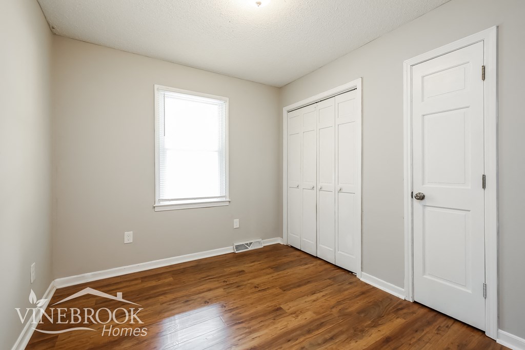 the living room of a home with a wood floor and white doors