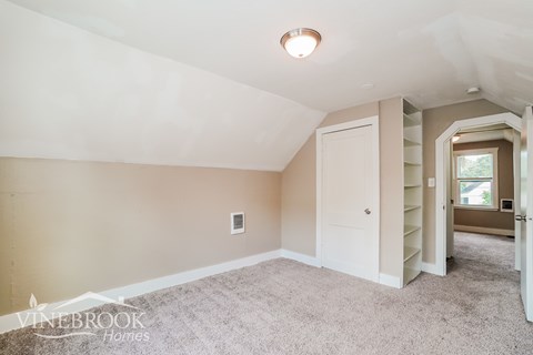 a living room with carpet and a door to a closet